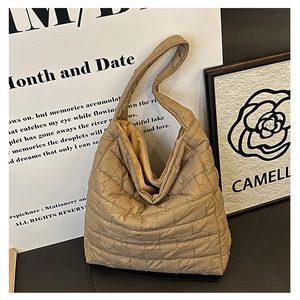 Detail of khaki quilted tote bag with soft padded fabric and square stitching pattern