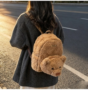 Détail d'un sac à dos ours en peluche avec plaque Lucky Bear sous la lumière