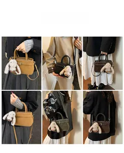 Detail view of stylish matte crossbody bag with belt buckle and cute plush bunny charm