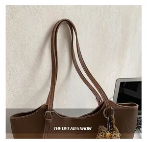 Close-up of brown pebbled leather tote bag with silver hardware and leopard print bow