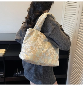Detail of quilted shoulder bag with Chinese embroidery showing shoulder fit on model