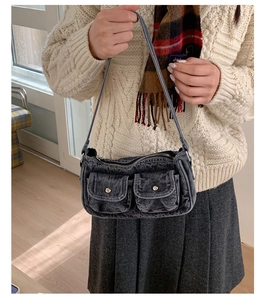 Close-up of retro washed denim shoulder bag with utility pockets on model
