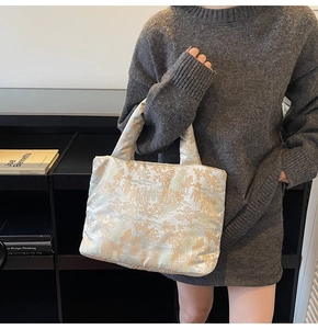 Quilted floral handbag in cream silk with vintage patterns held by a model