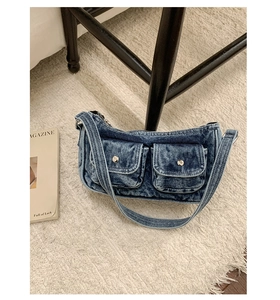 Detail of vintage washed denim shoulder bag with dual utility pockets and silver buttons