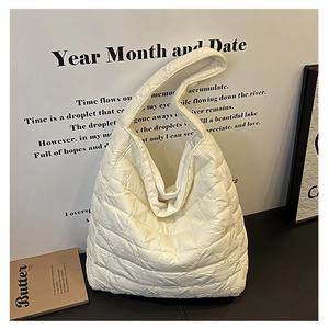 Detail shot of the cream white quilted texture and soft padded fabric on the tote bag