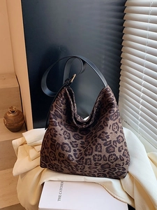 Chic leopard print hobo shoulder bag with black leather strap in home setting