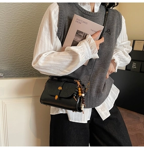 Detail of vintage black crossbody bag with decorative multicolor beads and brass clasp