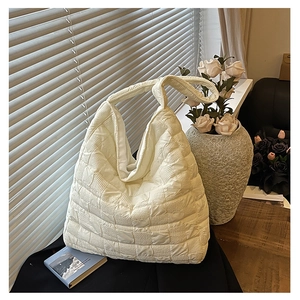 Detail of white quilted hobo bag with unique square texture for daily commute style