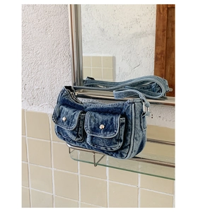 Detail of vintage washed denim tote bag with metal buckles reflected in a mirror