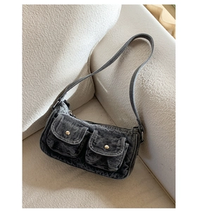 Close-up of vintage washed denim fabric texture and metal buttons on shoulder bag