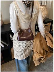 Détail du sac seau en cuir marron foncé avec logo HOGONU et finition texturée vintage
