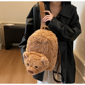 Détail d'un sac à dos ours en peluche marron avec oreilles 3D et sangles cuir