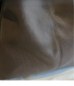 Close-up of brown faux leather tote bag showing soft lychee texture and durable stitching