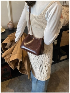 Vue détaillée d'un sac seau marron en cuir brillant avec texture fine et bandoulière