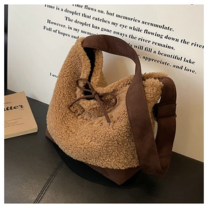 Close-up of khaki plush bucket bag with dark brown wide strap and bow detail