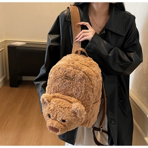 Détail d'un sac à dos ours en peluche avec fourrure marron et bretelles en cuir