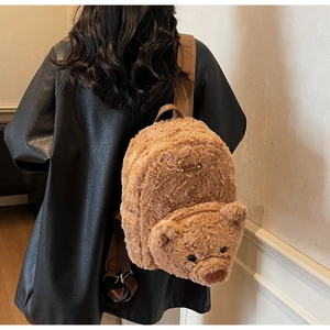 Détail d'un sac à dos ours en peluche marron avec bretelles en cuir et texture douce