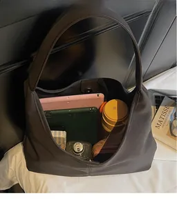 Detail view of large dark grey tote bag interior with tablets and water bottle storage