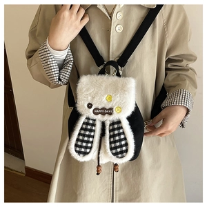 Detail of plush bunny backpack with rabbit ears and Happy Days tag on a model