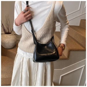 Sac seau noir chic avec logo HOGOMU en relief porté par un mannequin en intérieur