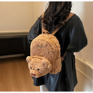 Détail du sac à dos peluche ours marron avec visage 3D et bretelles en cuir élégantes