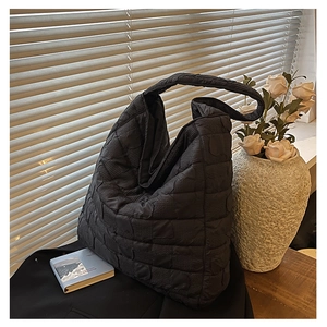 Detail of the bubble quilted texture and soft fabric on this large black tote bag