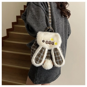 Detail of plush rabbit backpack with Happy Days label and brown plaid fabric straps