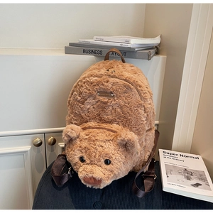 Vue détaillée du sac à dos en peluche ours brun avec bretelles réglables et plaque en métal