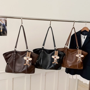 Detailed display of three vintage tote bags in black and brown with bunny charms