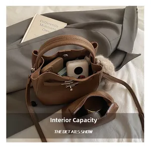 Macro view of brown lychee grain leather handbag showing internal capacity and inner pouch
