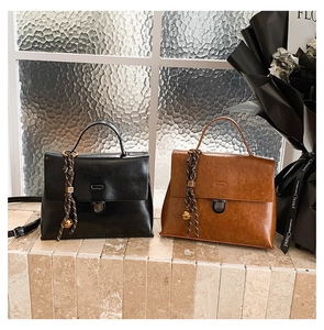 Detail von Vintage-Ölleder-Taschen in Schwarz und Braun mit Metallschnallen