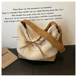 Close-up of beige faux fur shoulder bag with brown strap and bow tie detail
