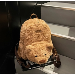 Détail du sac à dos peluche ours avec plaque dorée et texture douce en fausse fourrure