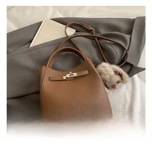 Detailed shot of brown litchi grain leather bucket bag with cute plush bunny pendant