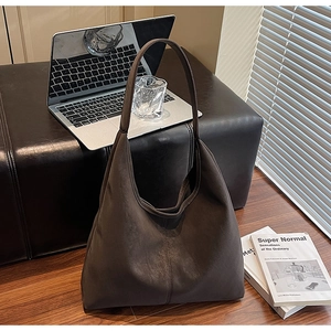 Large dark brown frosted leather tote bag shown in a professional office setting context