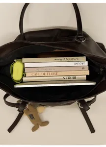 Top view of spacious deep brown tote bag interior with tablet, books and daily items