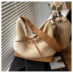 Detail of soft white sherpa fabric with brown suede strap and delicate bow decoration