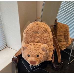 Détail du sac à dos peluche ours marron avec étiquette en métal et texture de fourrure