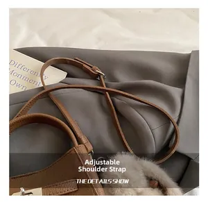 Close-up of adjustable strap and silver buckle on a brown lychee pattern leather bucket bag