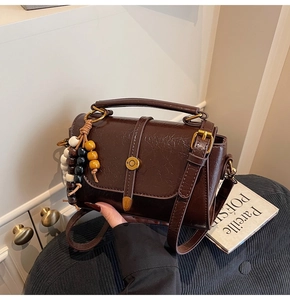 Detailed macro view of brown vintage leather bag with retro wood beads and golden hardware