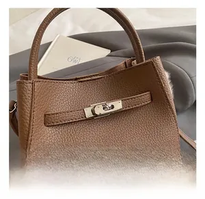Detail of brown litchi leather bucket bag showing silver lock and fuzzy wool lining