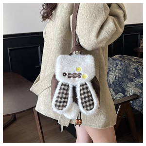 Détail d'un sac à dos lapin en peluche avec broderie Happy Days et oreilles à carreaux