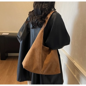 Detail view of large brown faux suede tote bag showing hobo style drape and texture