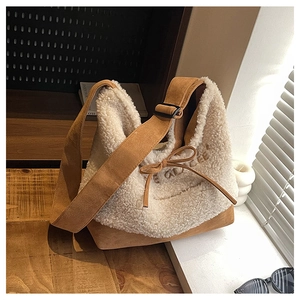Detail of fuzzy bucket bag with cream lamb wool, brown suede, and bow decoration