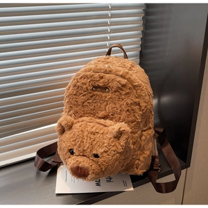 Détail d'un sac à dos ours en peluche marron avec plaque métallique Lovely Bear