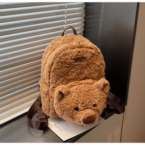 Détail du sac à dos ours en peluche avec fourrure douce et logo en métal doré brillant