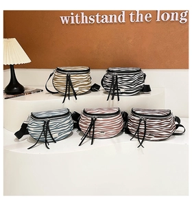 Detail verschiedener Zebra-Umhängetaschen mit Lederquasten-Reißverschluss-Anhängern