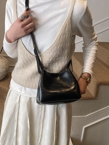 Sac seau classique en cuir noir avec logo embossé et bandoulière réglable pour femme