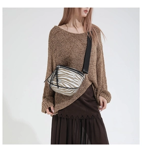 Detail der Crossbody-Tasche mit Zebramuster Quasten-Reißverschluss und Nylon-Riemen