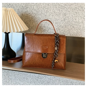 Detailansicht einer Vintage-Handtasche aus braunem Leder mit Metallschnalle